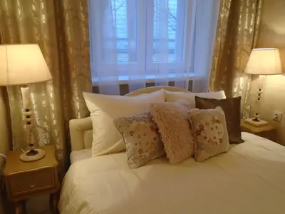 a bedroom with a white bed with pillows and a window at Apartment Bourgeois in Belgrade