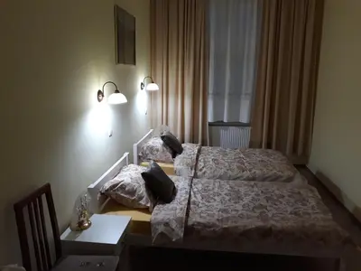 a bedroom with two beds and a table and lights at Prenociste Nikolas Grand in Smederevo