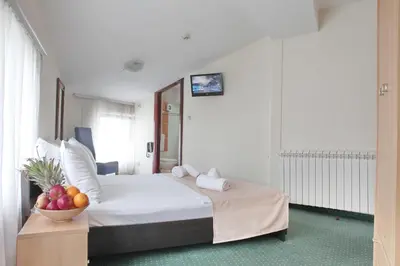 a bedroom with a bed with a bowl of fruit on a table at Happy Star Club in Belgrade
