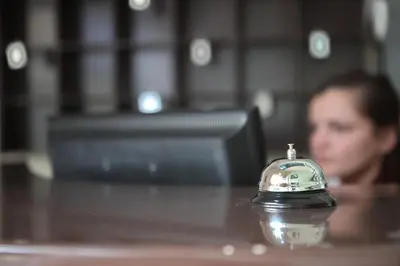 a man sitting at a table with a clock on a table at Happy Star Club in Belgrade