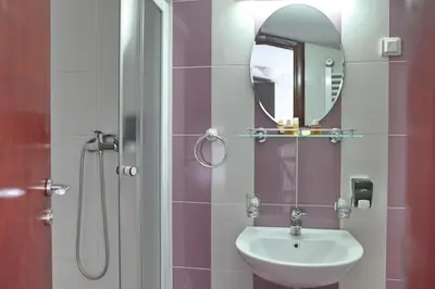 a bathroom with a sink and a shower with a mirror at Happy Star Club in Belgrade