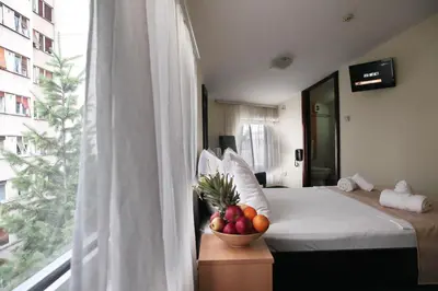 a bedroom with a bed with a bowl of fruit on a table at Happy Star Club in Belgrade