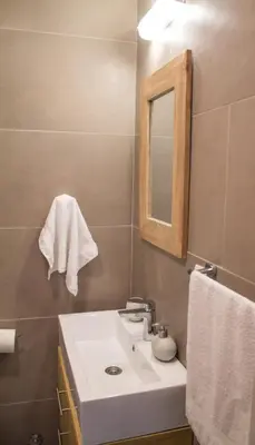 a bathroom with a white sink and a mirror at Bardolino Apartment in Belgrade