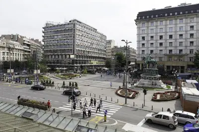 a city with cars and people walking around a street at Bardolino Apartment in Belgrade