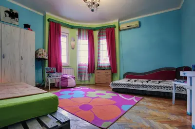 a colorful room with two beds and a rug at Apartment Dorcol in Belgrade