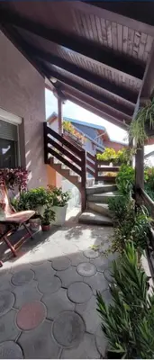 a patio with potted plants and a wooden railing at Jezero in Arandjelovac