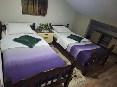 two beds in a room with purple and white at Jezero in Arandjelovac