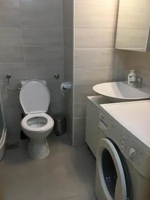 a bathroom with a toilet and a sink and a washing machine at Stardust Belgrade in Belgrade