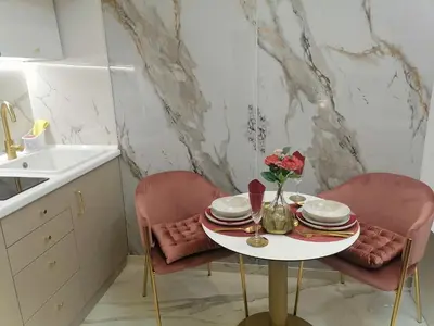 a table with plates and flowers on it in a kitchen at Apartment Lovac in Belgrade