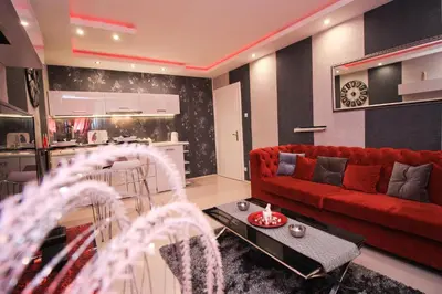 a living room with a red couch and a kitchen at Apartment Lovac in Belgrade