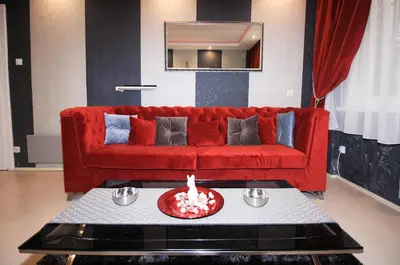 a red couch in a living room with a table at Apartment Lovac in Belgrade
