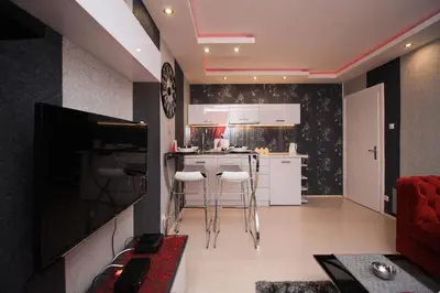 a living room with a kitchen with white cabinets at Apartment Lovac in Belgrade