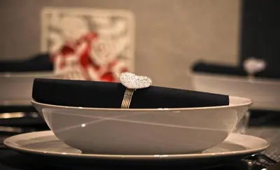 a white bowl on a plate with a engagement ring in it at Apartment Lovac in Belgrade
