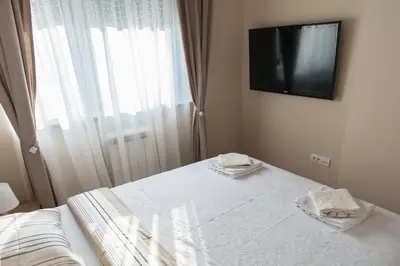 a bedroom with a bed with a television on the wall at Apartment Ada in Belgrade