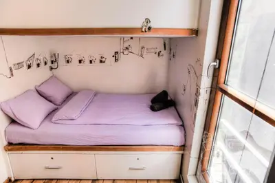 a small bed in a tiny house at ArkaBarka Floating Hostel in Belgrade