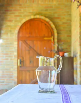 a glass vase sitting on a table with a table cloth at etno dom 