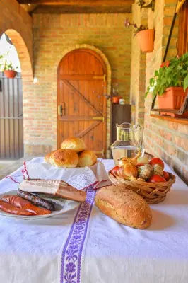 a table with two plates of bread and a basket of food at etno dom 