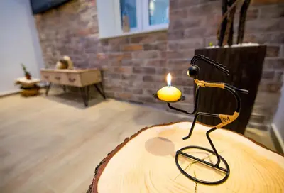 a candle sitting on top of a wooden table at Cosmopolitan Apartment in Belgrade