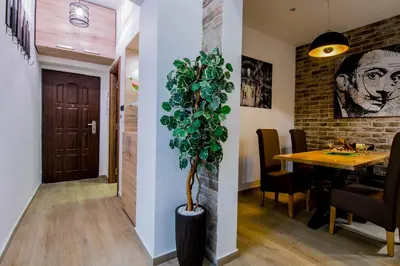 a dining room with a table and a plant at Cosmopolitan Apartment in Belgrade