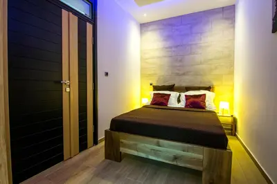 a bedroom with a bed with a wooden head board at Cosmopolitan Apartment in Belgrade