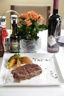 a plate of food with a piece of meat on a table at Accommodation Tara in Belgrade
