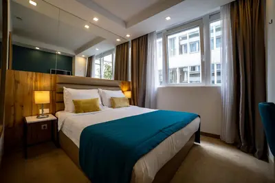 a bedroom with a large bed with a blue blanket at MARK Hotel in Belgrade