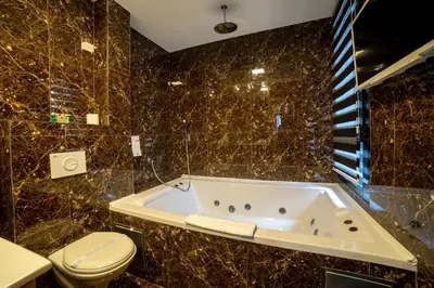 a bathroom with a tub and a toilet at MARK Hotel in Belgrade