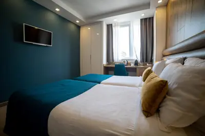 a bedroom with a large bed with a blue wall at MARK Hotel in Belgrade