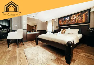 a bedroom with a large bed and a white chair at Lux apartmani Beograd in Belgrade