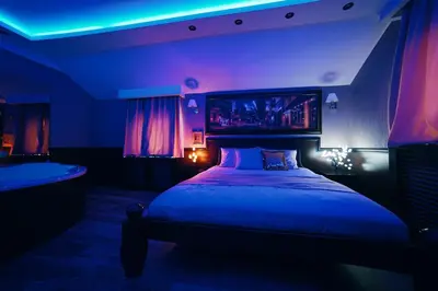 a bedroom with a bed with a blue and purple lighting at Lux apartmani Beograd in Belgrade