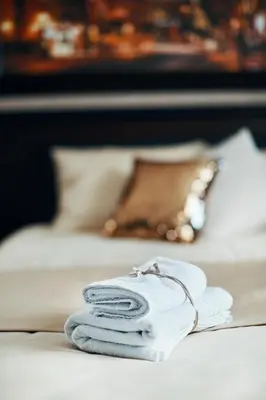 a pile of towels sitting on a bed at Lux apartmani Beograd in Belgrade