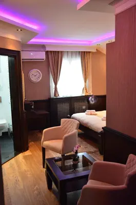 a bedroom with a bed and a table and purple lighting at Lux apartmani Beograd in Belgrade
