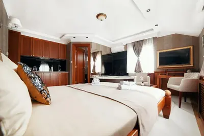 a bedroom with a large bed and a chair at Lux apartmani Beograd in Belgrade