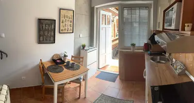 a kitchen with a small table and a kitchen with a sink at Garsonjera Zvezdara in Belgrade