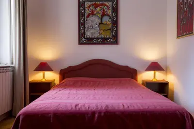 a bedroom with a pink bed with two lamps at Sun Hostel in Belgrade