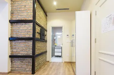 a room with a brick wall and a hallway at Marquise Hotel Garni in Belgrade