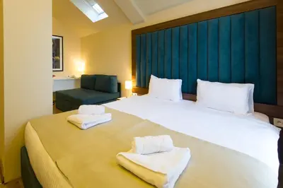 a bedroom with a large bed with towels on it at Marquise Hotel Garni in Belgrade
