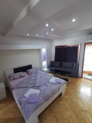 a bedroom with a large bed and a couch at Marmelo Loft in Belgrade