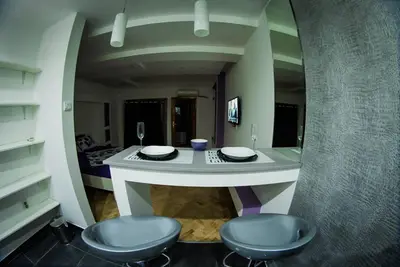 a kitchen with two stools and a table in a room at Marmelo Loft in Belgrade