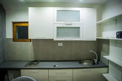 a kitchen with white cabinets and a sink at Marmelo Loft in Belgrade