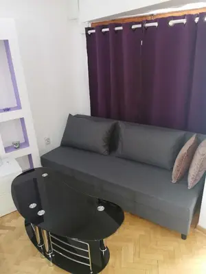 a couch in a room with a purple curtain at Marmelo Loft in Belgrade