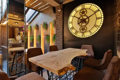 a room with a table and a clock on the wall at Hotel Passpartù Home Garni in Belgrade