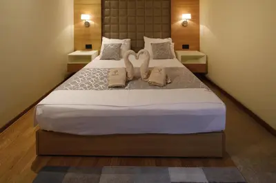 a bedroom with a large bed with two swans on it at Hotel Passpartù Home Garni in Belgrade
