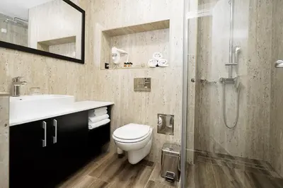 a bathroom with a toilet and a sink and a shower at Hotel Srbija Lux in Stara Pazova