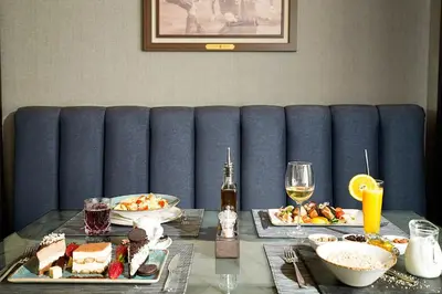 a table with plates of food and drinks on it at Hotel Srbija Lux in Stara Pazova