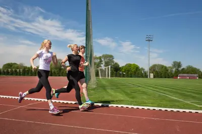 three women are running on a tennis court at Hotel Srbija Lux in Stara Pazova