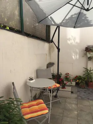 a table and chairs with an umbrella on a patio at Crown Street Garden Studio in Belgrade