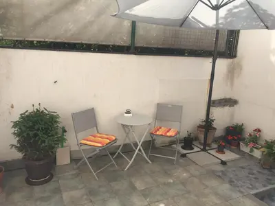 a patio with two chairs and a table and some plants at Crown Street Garden Studio in Belgrade