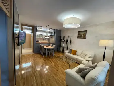 a living room with a couch and a dining room at Booky Apartment in Belgrade