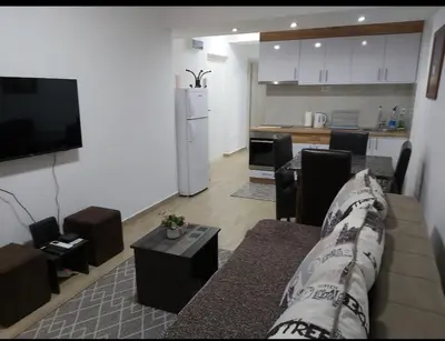 a living room with a couch and a kitchen at Apartment Violet in Belgrade